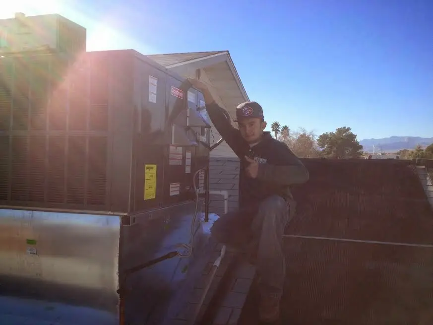 HVAC technician performing HVAC Inspection on a rooftop unit in East Allen